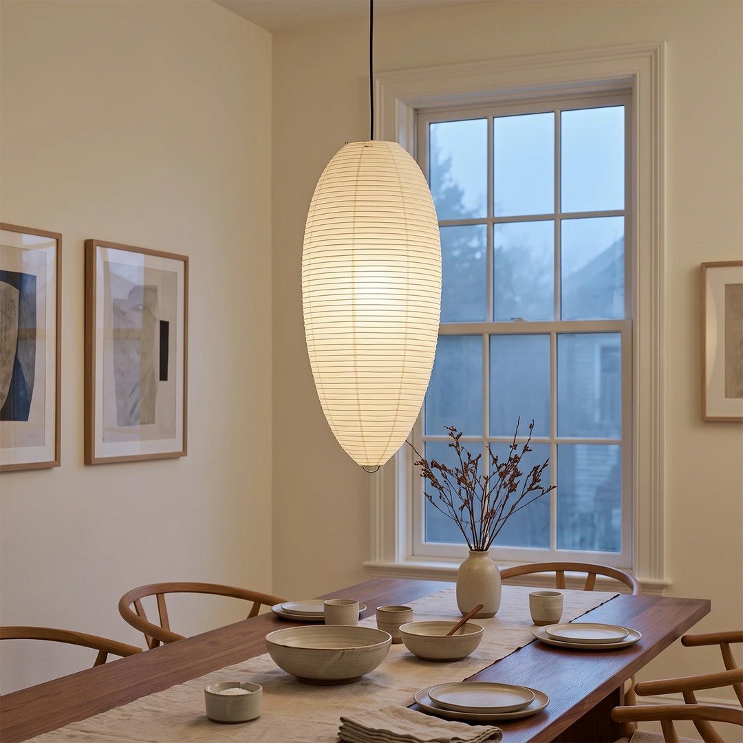 Oval paper pendant above a dining table under an A-frame beamed ceiling