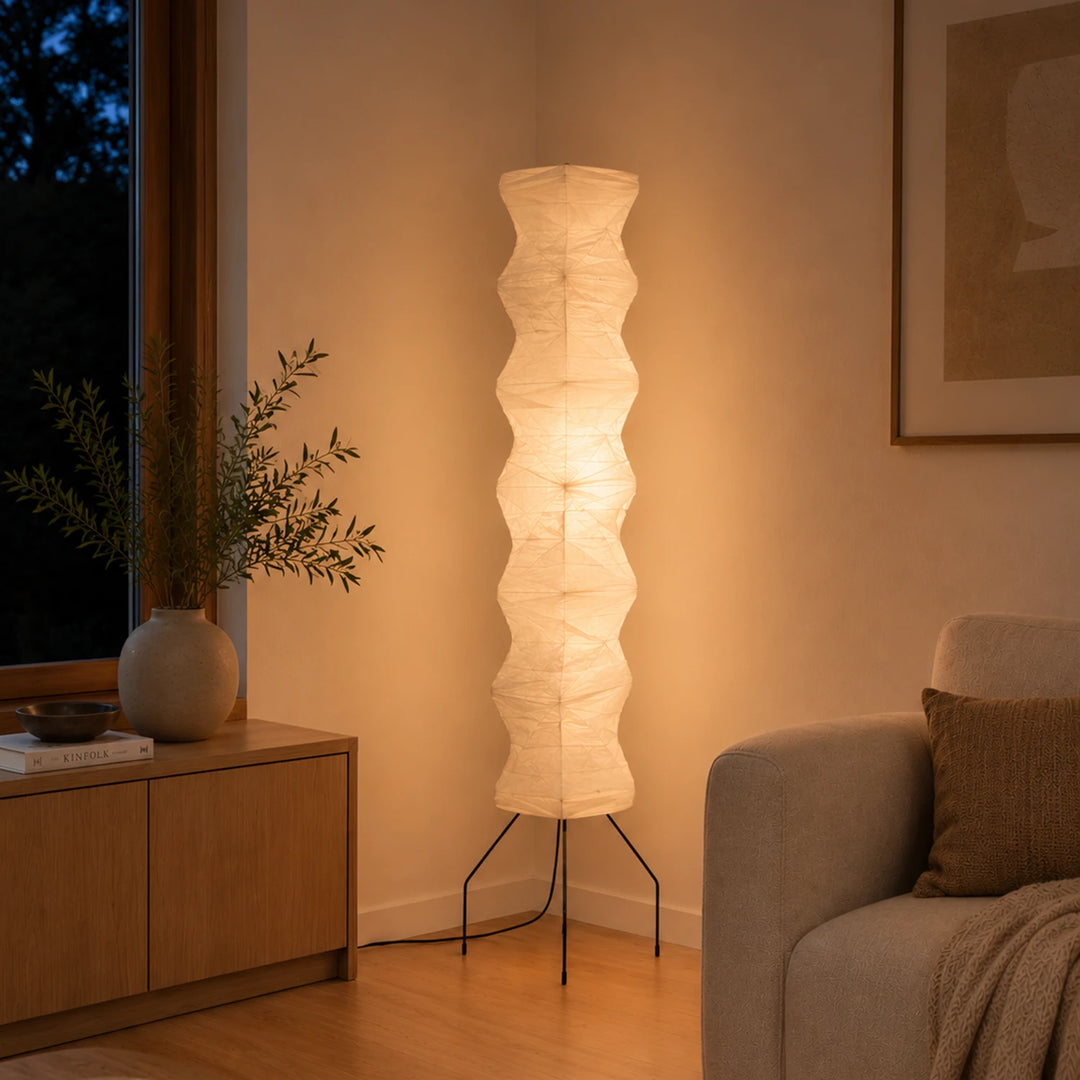Paper floor lamp glowing at dusk in a living room with mountain views
