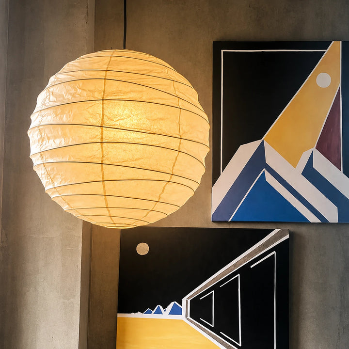 Paper pendant lighting a corner with colorful framed gallery artwork