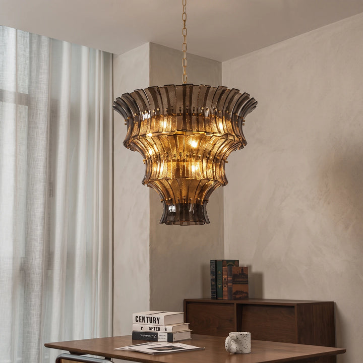 Amber fluted glass chandelier lit above a wooden desk in a warm office nook