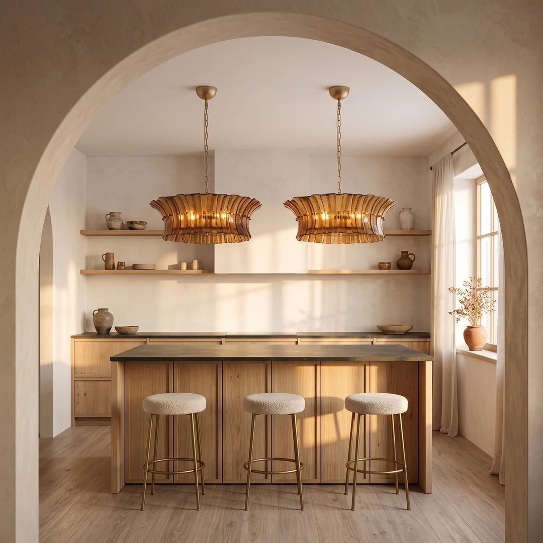 Two amber glass pendants seen through a plaster archway above a kitchen counter
