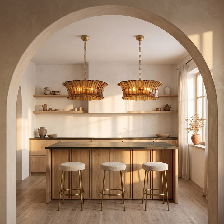 Two amber glass pendants seen through a plaster archway above a kitchen counter