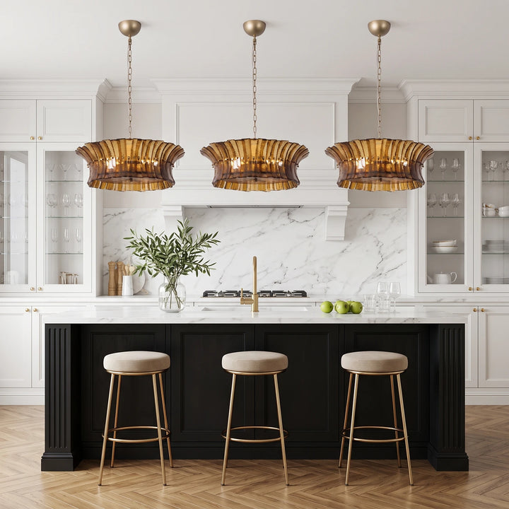 Three amber glass pendants lined up above a black kitchen island
