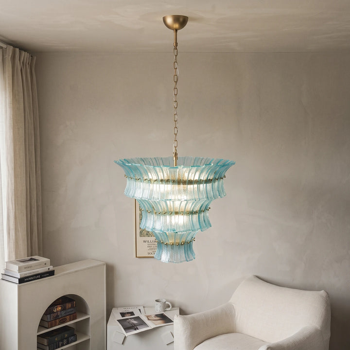 Aqua fluted chandelier hanging against a smooth plaster wall in a quiet living space