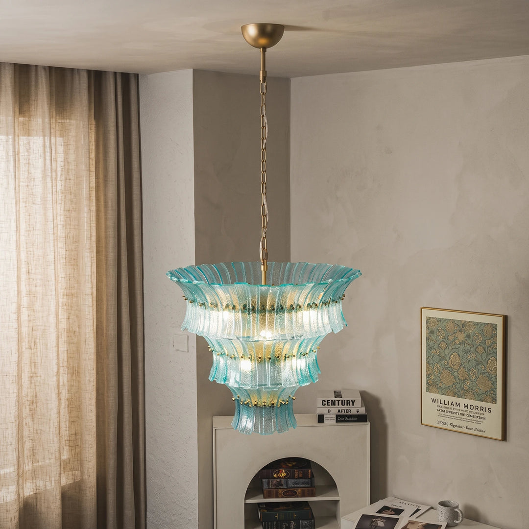 Aqua fluted chandelier glowing in a warm plaster corner beside linen curtains