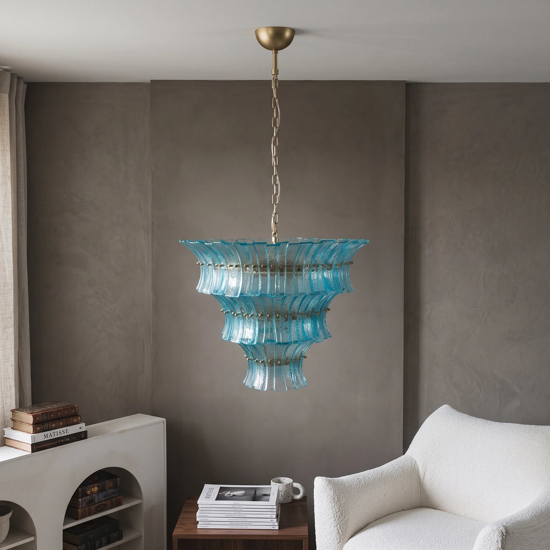 Aqua glass chandelier above a reading corner with a pale armchair
