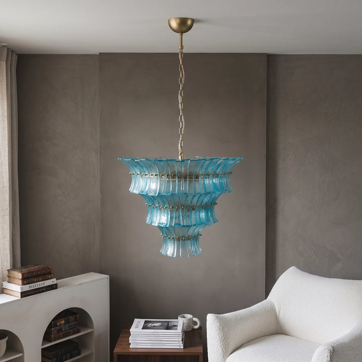 Aqua glass chandelier above a reading corner with a pale armchair