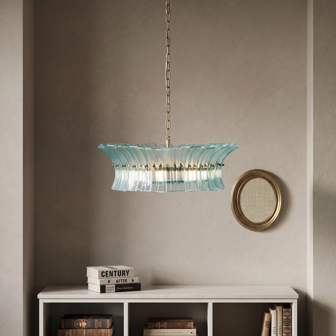 Aqua glass chandelier hanging near a small round mirror on a plaster wall