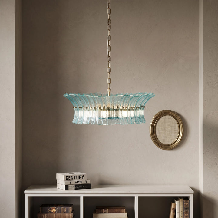 Aqua glass chandelier hanging near a small round mirror on a plaster wall