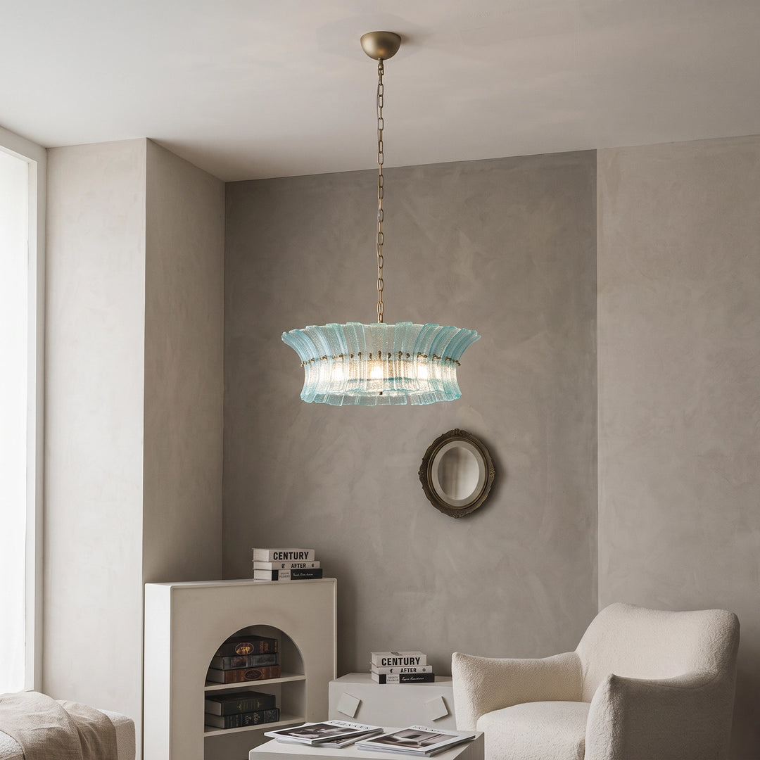 Aqua glass chandelier lighting a soft taupe corner with a round wall mirror