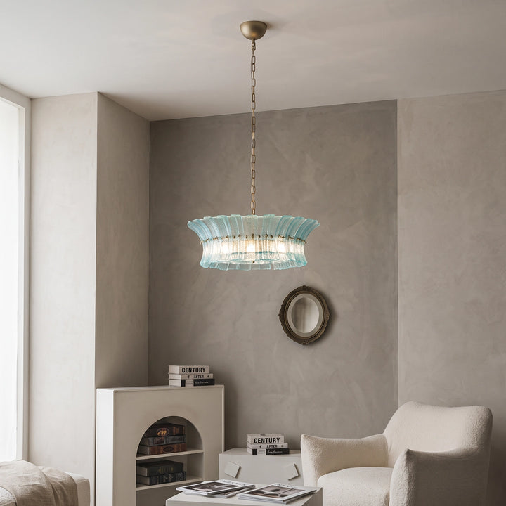 Aqua glass chandelier lighting a soft taupe corner with a round wall mirror
