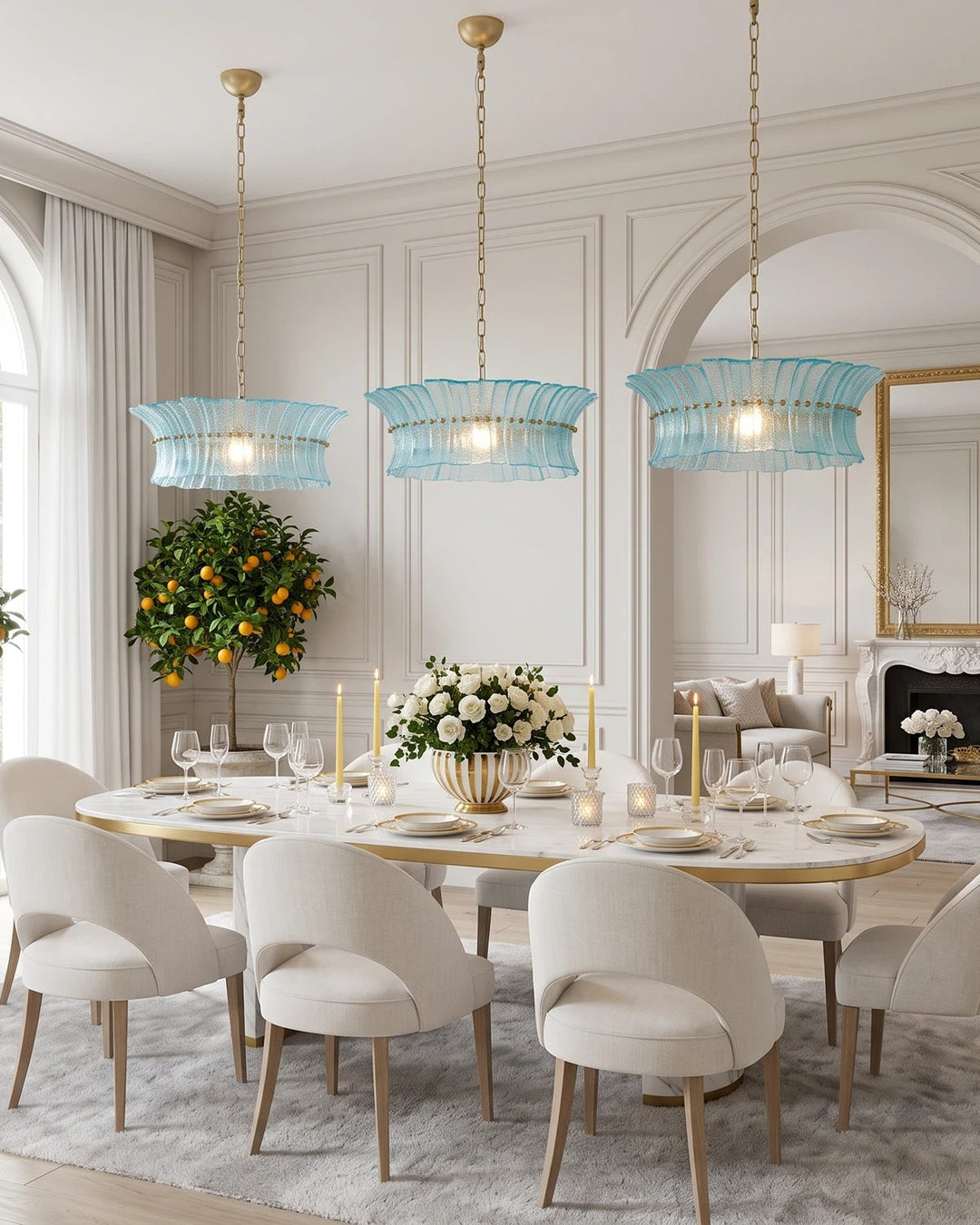 Three aqua glass chandeliers spaced above a long oval dining table