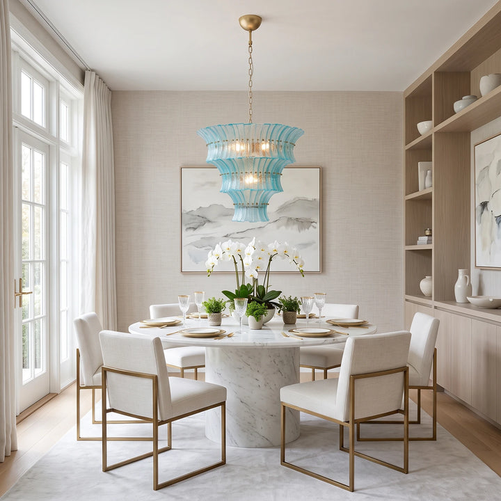 Aqua glass chandelier above a round table in a bright white dining room