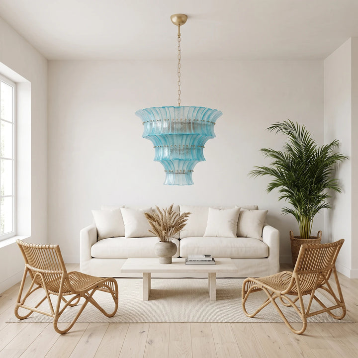 Aqua glass chandelier in a white sunroom with rattan chairs and palms