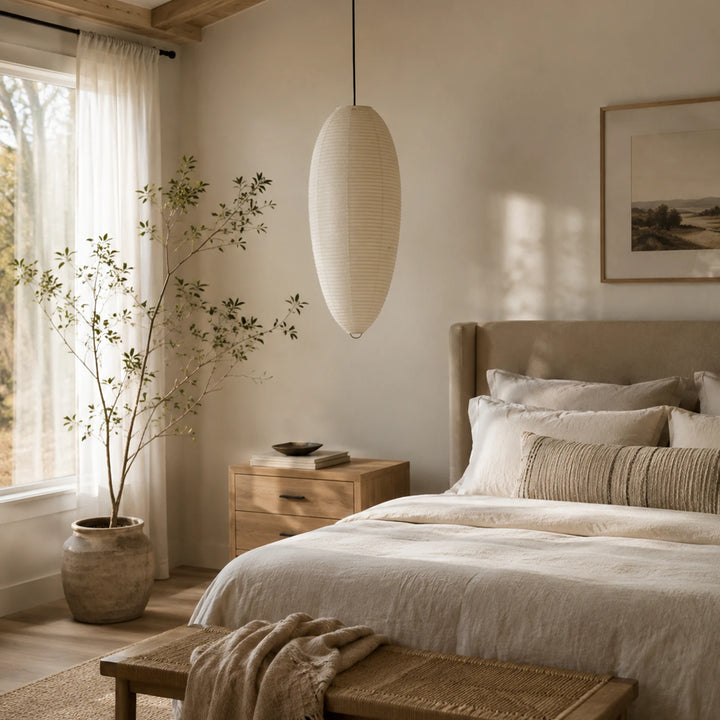 Oval paper pendant in a bedroom with framed art and a leafy indoor tree