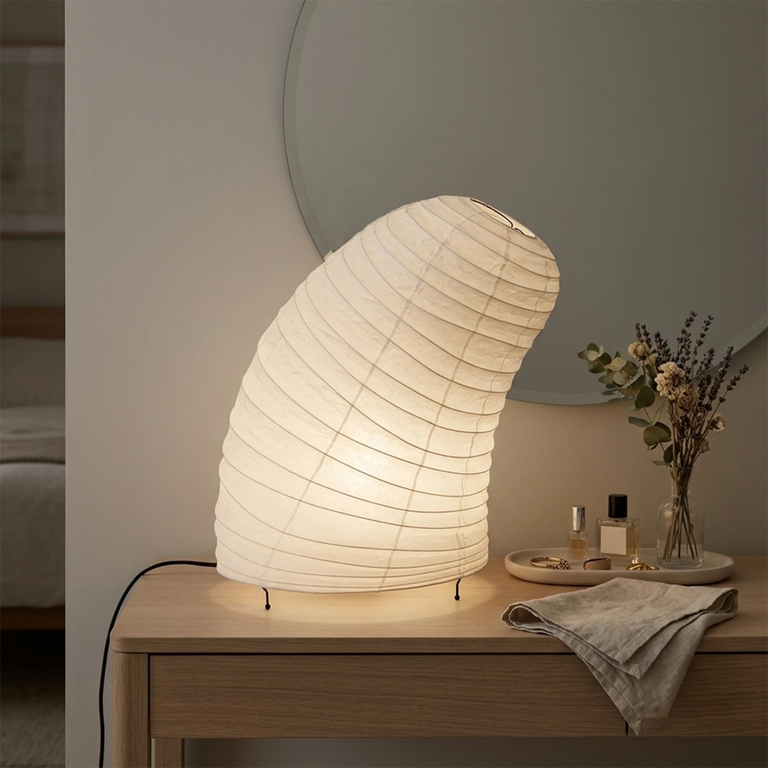 Curved paper table lamp glowing on a coffee table in a warm lounge