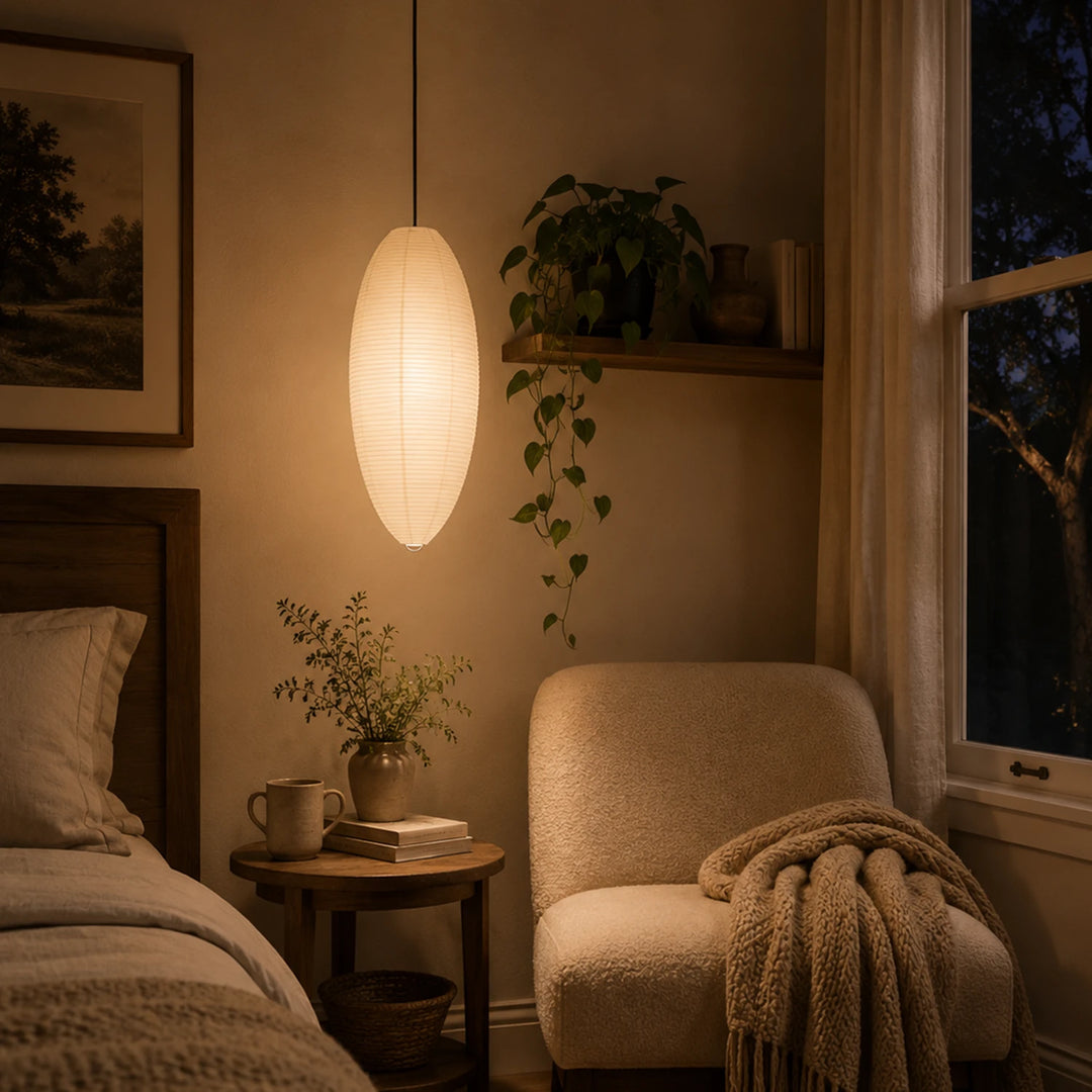 Oval paper pendant glowing in a cozy lounge beside a trailing plant