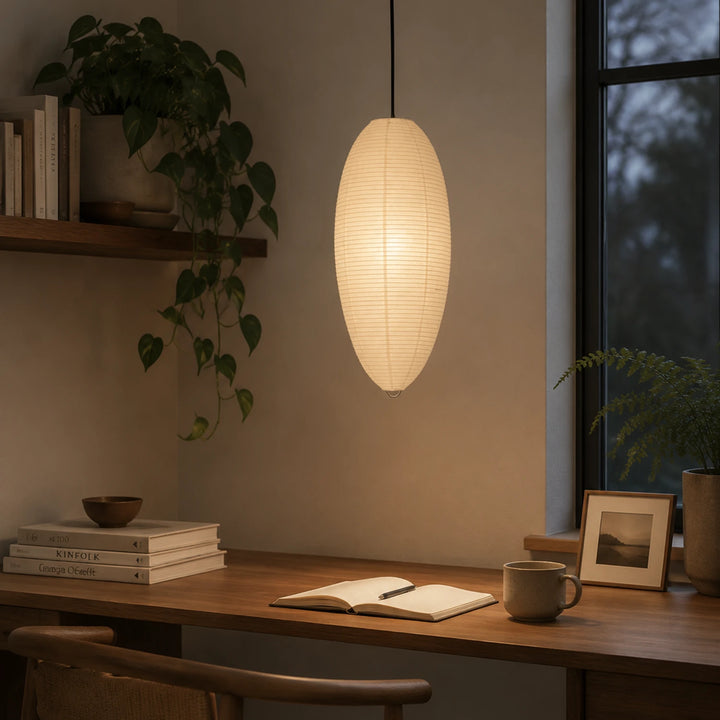 Oval paper pendant casting warm light over a small desk nook