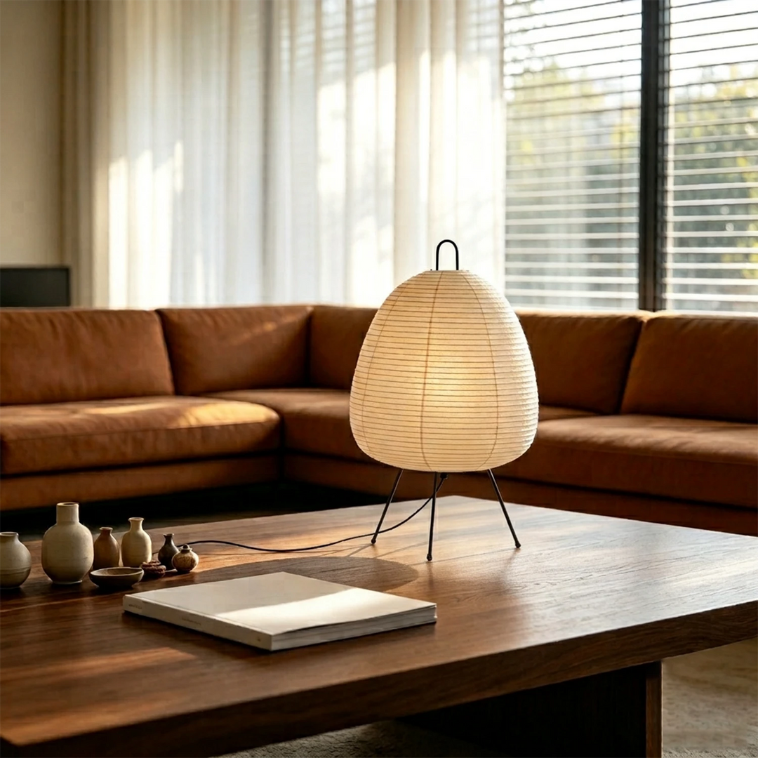 Egg-shaped paper lamp on a walnut coffee table beside a tan leather sofa