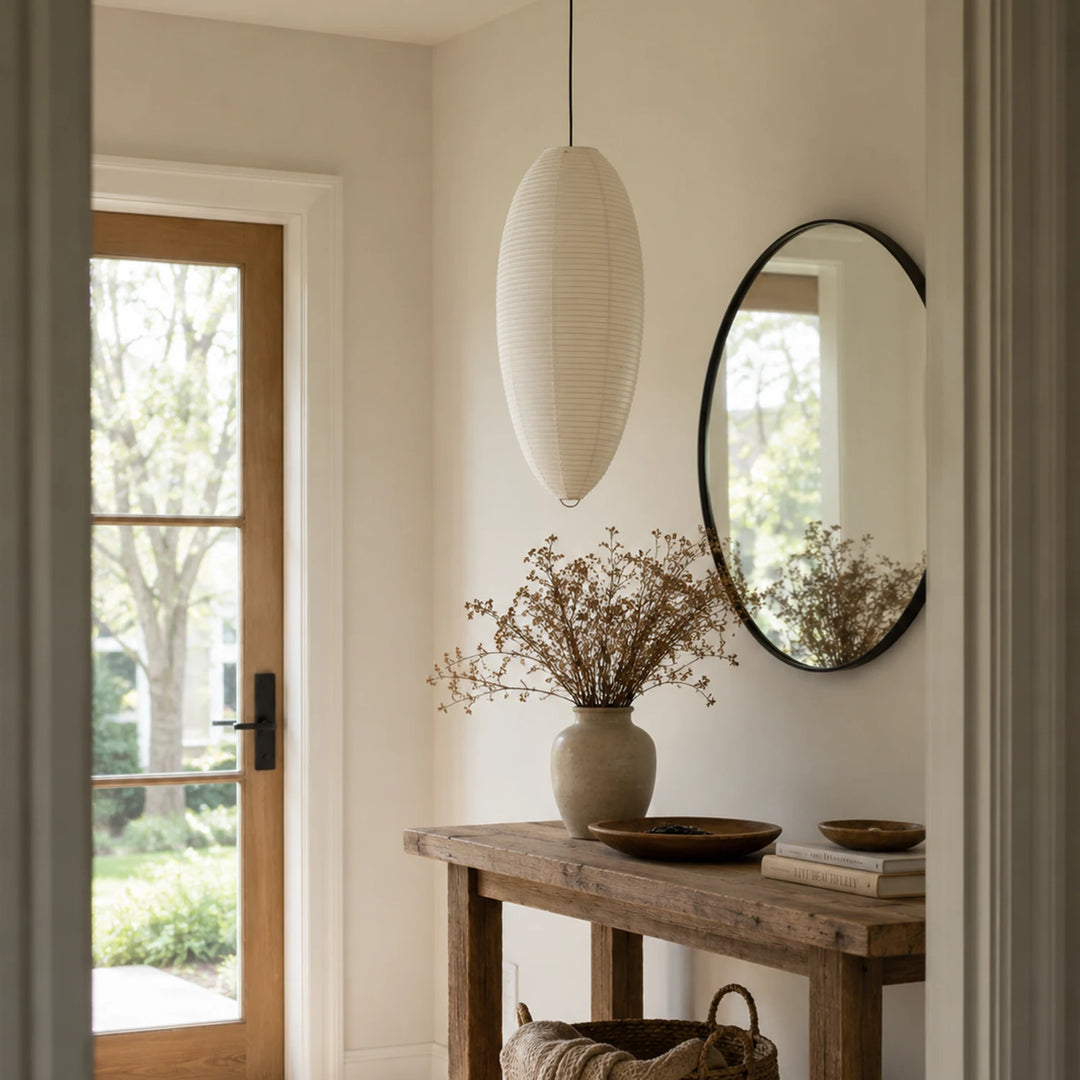 Oval paper pendant in an entryway beside a round mirror and console table
