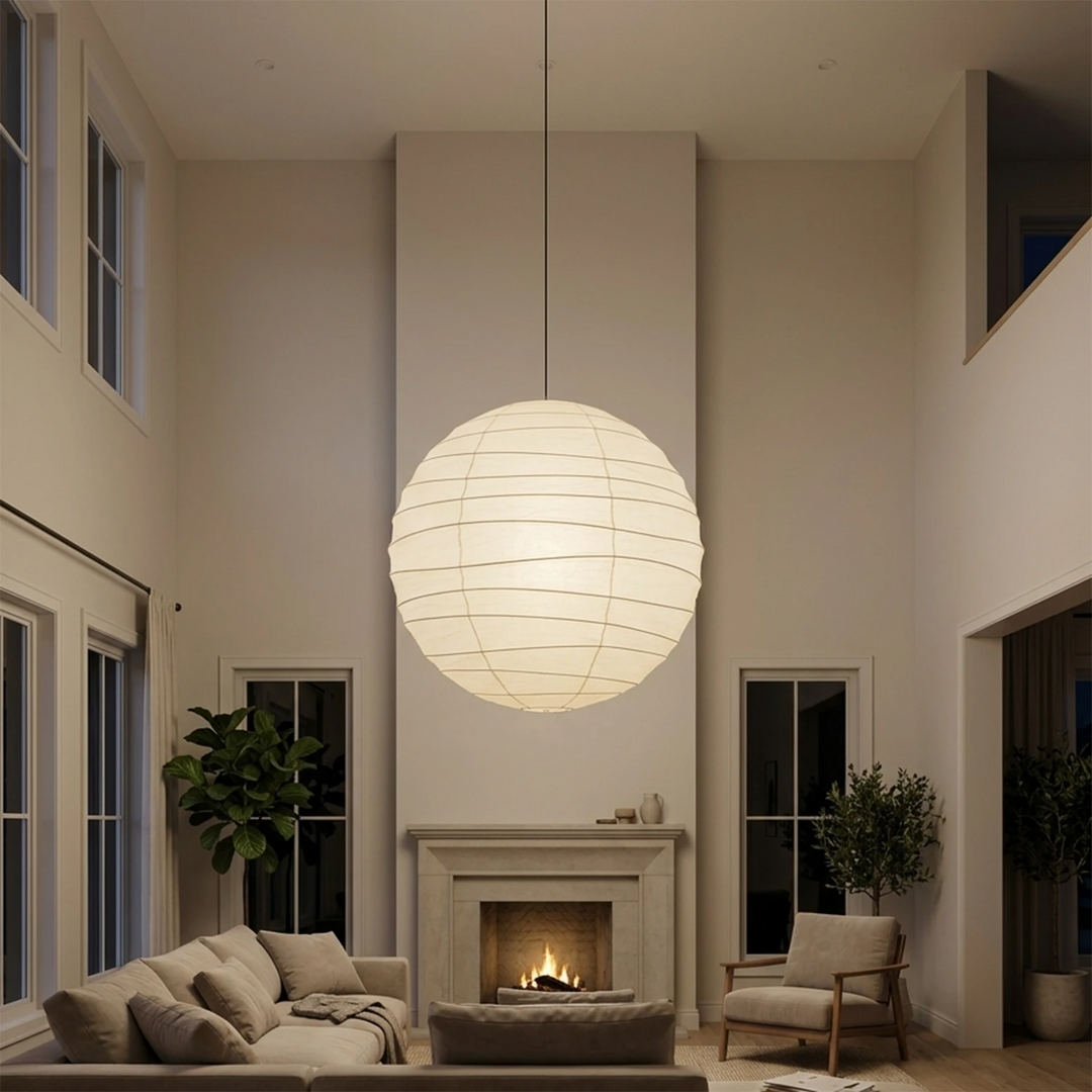 Paper pendant glowing in a tall living room beside a stone fireplace
