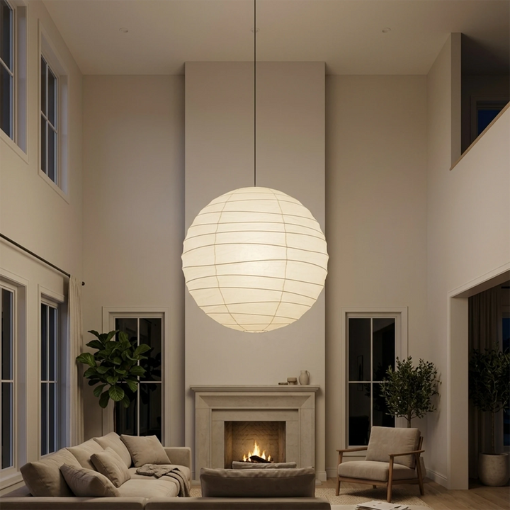 Paper pendant glowing in a tall living room beside a stone fireplace