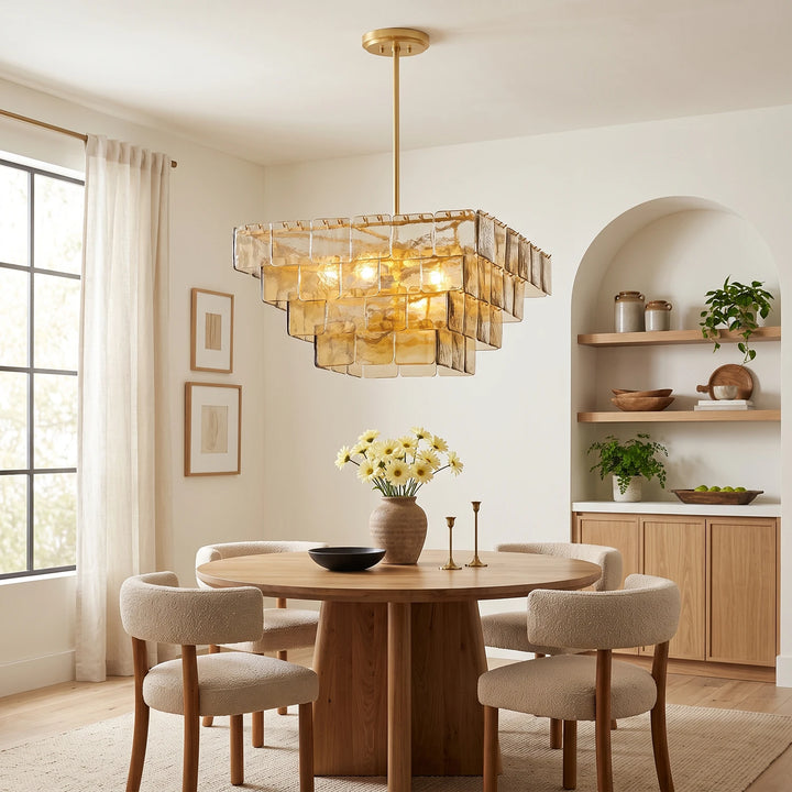 Glass tile chandelier centered over a round table beside a plaster arch niche
