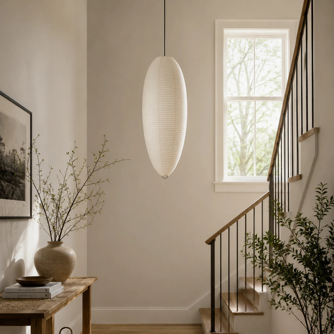 Oval paper pendant lighting a hallway leading toward a bright kitchen