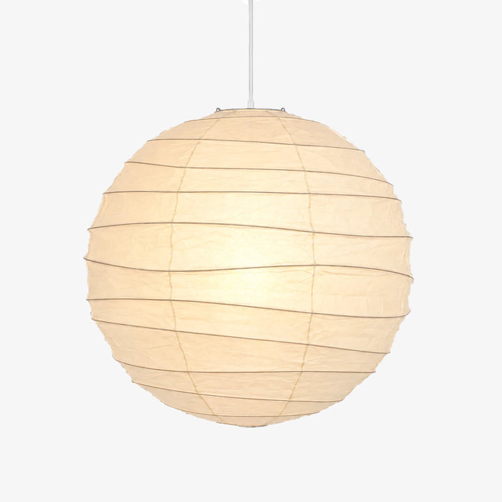 Paper ball light shown lit against a pale grey studio backdrop