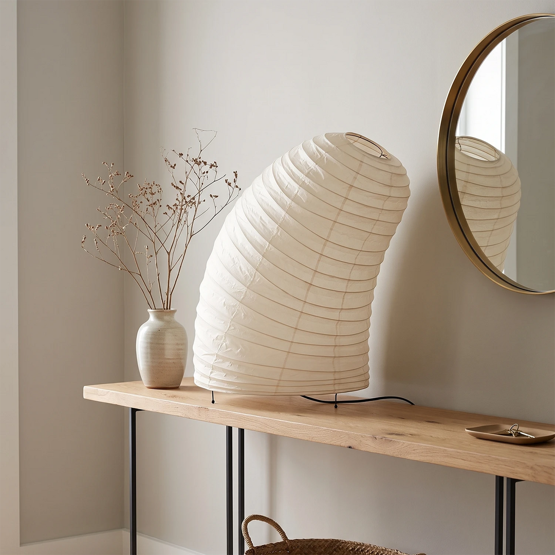 Sculptural paper lamp glowing on a home-office desk in the evening