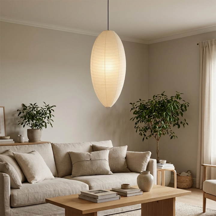 Oval paper pendant in a neutral living room beside a linen sofa and olive tree