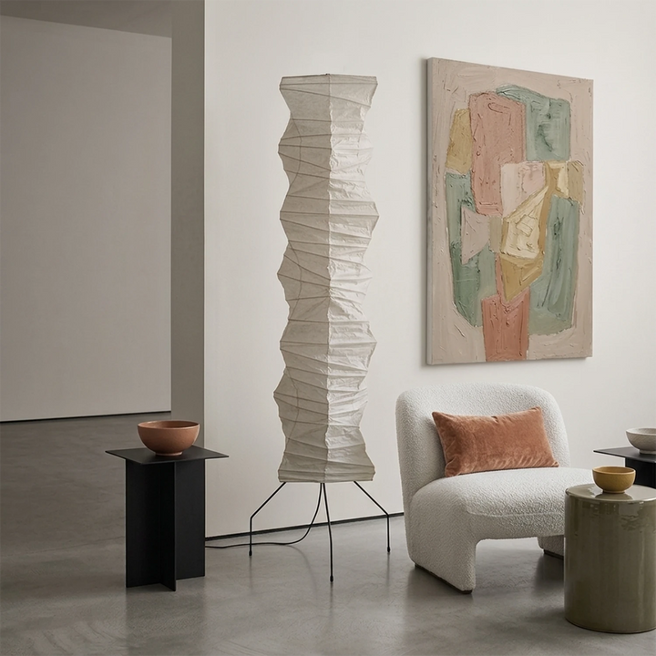 Modern paper floor lamp in a styled corner with abstract wall art and bouclé chair