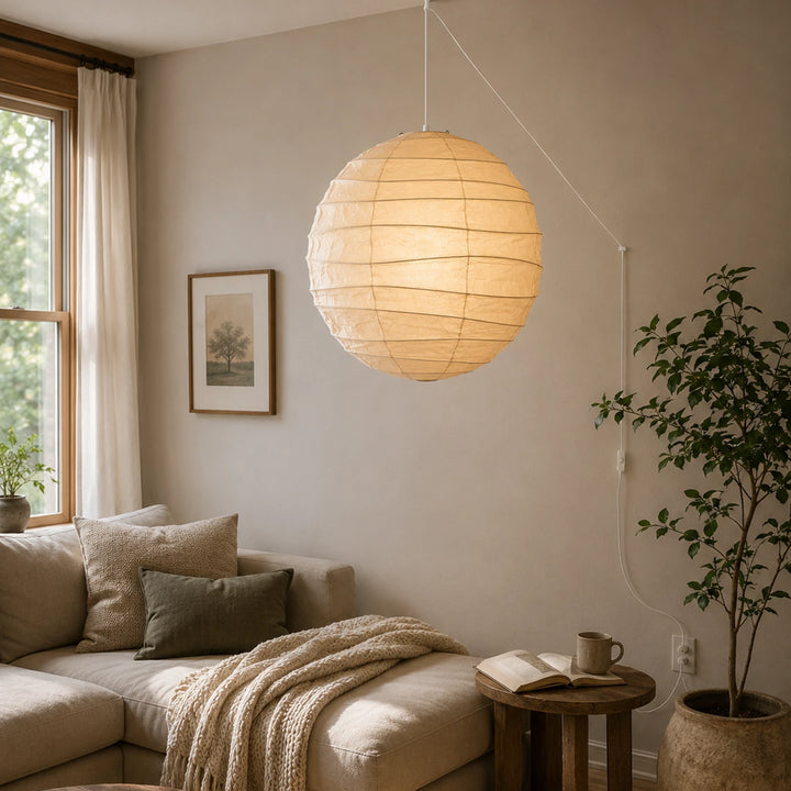 Paper globe pendant hanging in a neutral living room above a linen sofa