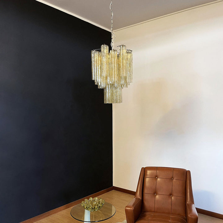 Murano Glass Tube Chandelier with amber gold glass in a room with a leather chair