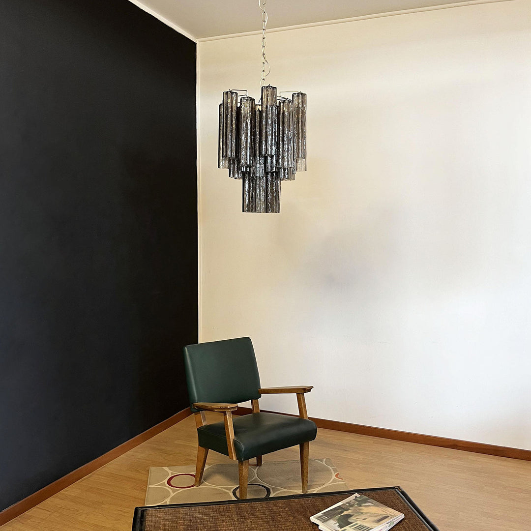 Murano Glass Tube Chandelier with smoke gray glass against a black wall with a leather chair