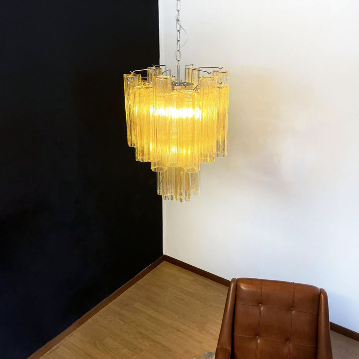 Murano Glass Tube Chandelier with warm yellow glass against a black wall with leather chair