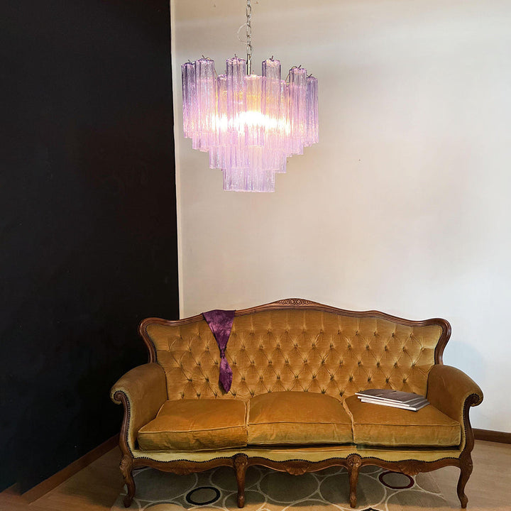 Murano Star Tube Chandelier with amber glass against a black accent wall with two green chairs