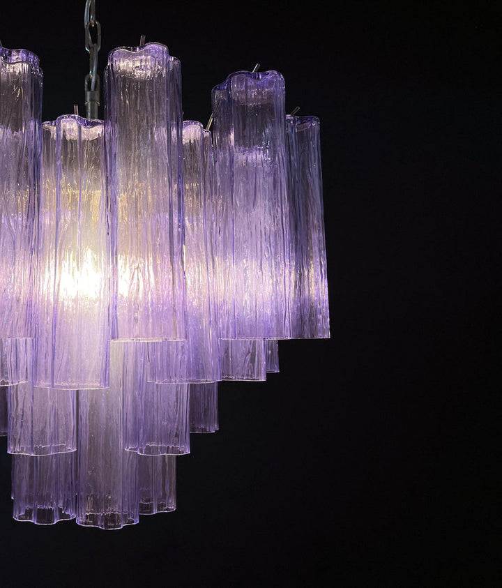 Close-up of lit amber Murano glass tubes showing warm light through rippled texture