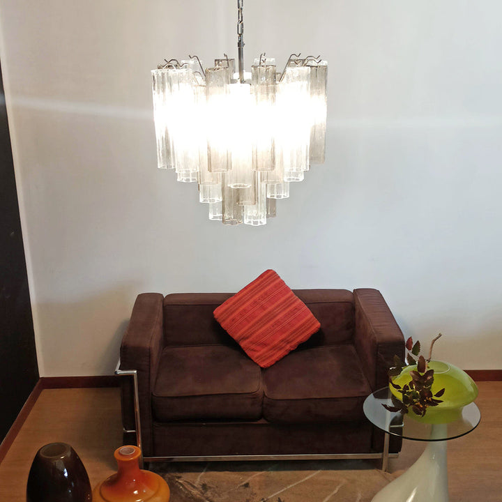 Murano Star Tube Chandelier with clear glass tubes against a black accent wall with a brown sofa
