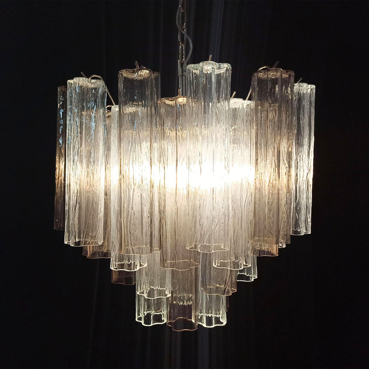 Lit Murano Star Tube Chandelier with clear glass tubes against a dark accent wall