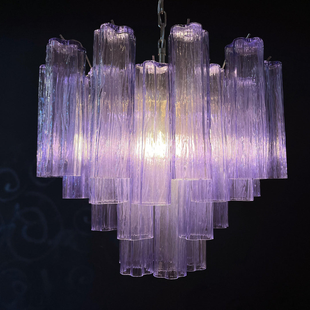 Lit Murano Star Tube Chandelier with vibrant purple glass tubes against a dark accent wall