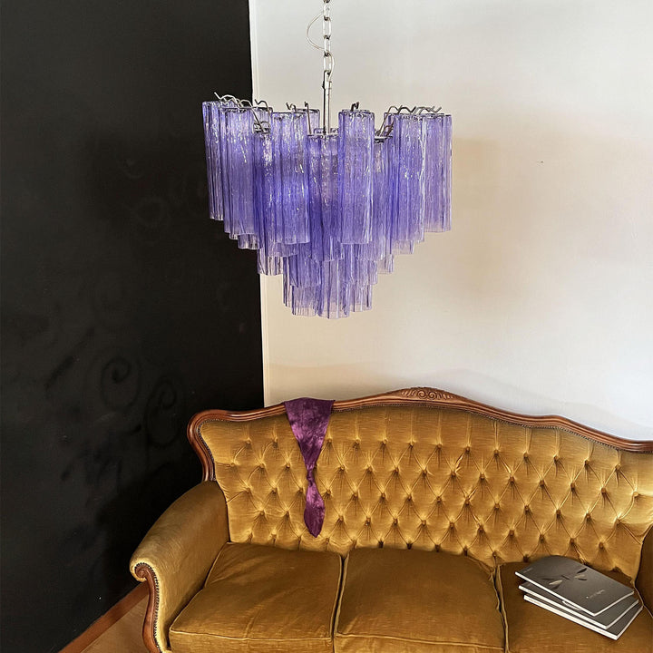 Murano Star Tube Chandelier with turquoise blue glass against a black accent wall with a white chair