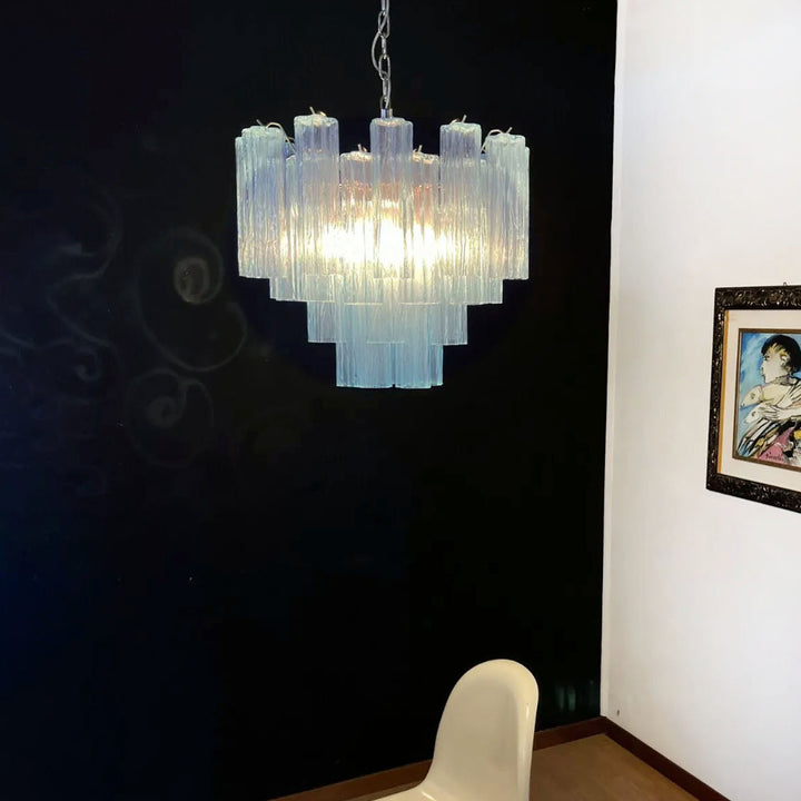 Lit Murano Star Tube Chandelier with turquoise glass in a corner with framed art