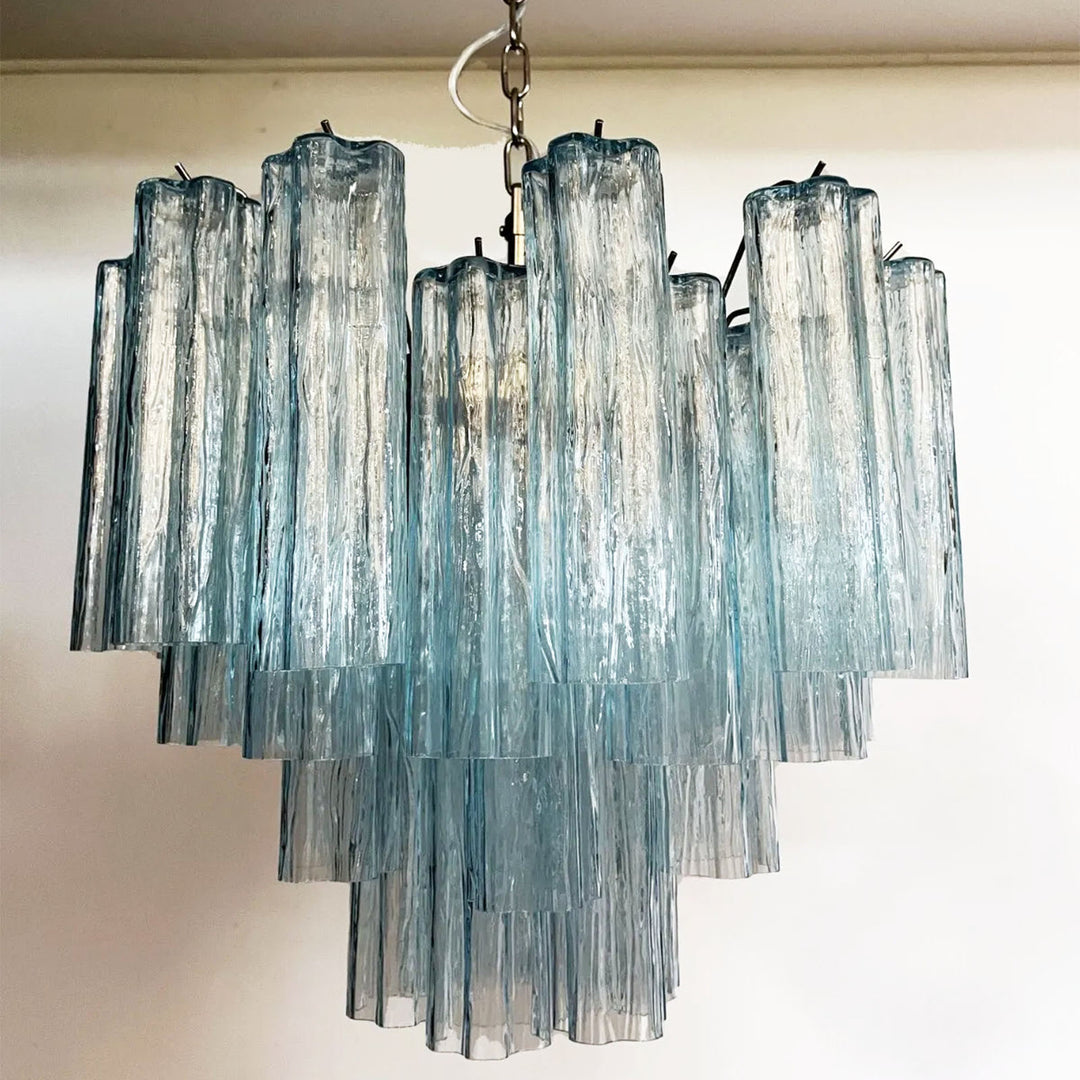 Lit Murano Star Tube Chandelier with turquoise blue glass tubes in a dark corner