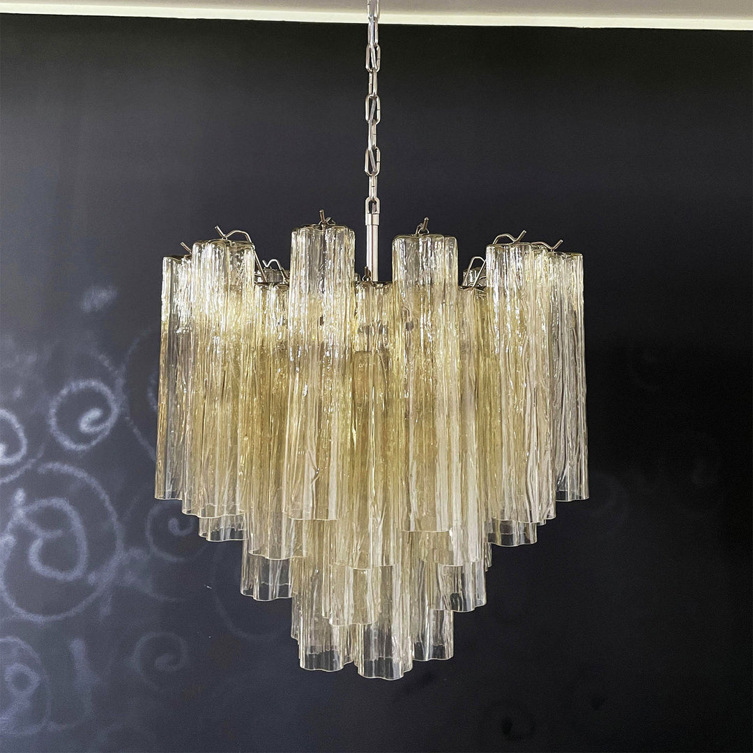 Lit Murano Star Tube Chandelier with turquoise blue glass tubes against a dark accent wall