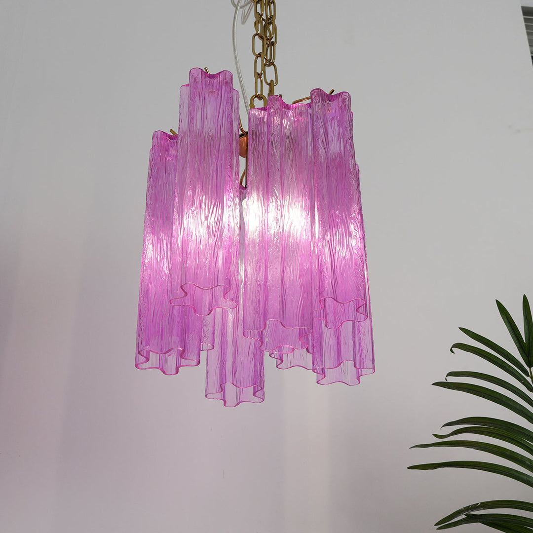 Murano Tubes Glass Chandelier with vibrant purple glass on a plain white wall with tropical plants