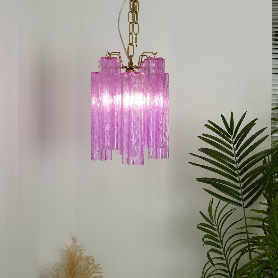 Murano Tubes Glass Chandelier with vibrant purple glass hanging in a bright room with tropical plants