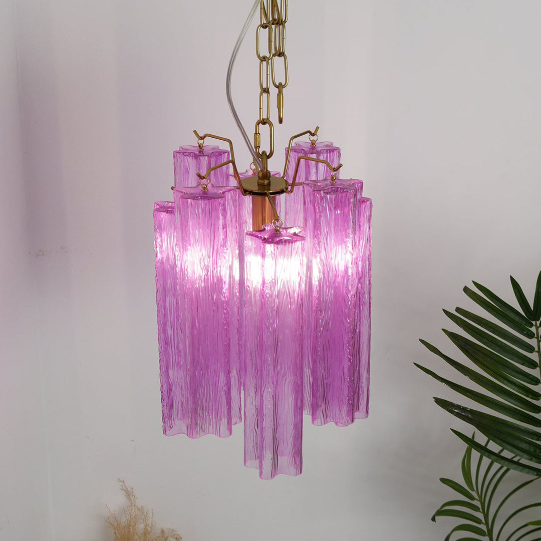 Murano Tubes Glass Chandelier with purple glass and gold chain on a plain white wall with tropical plants