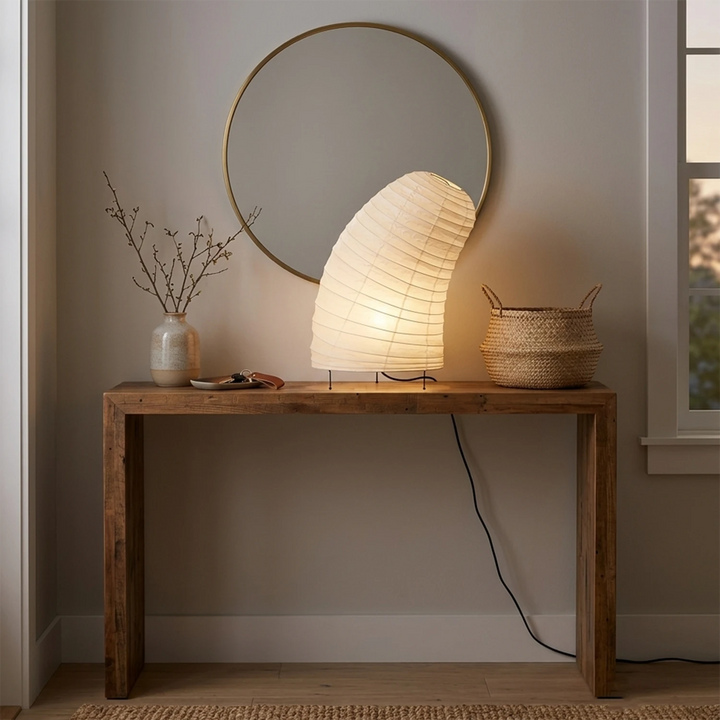 Curved paper table lamp casting a warm evening glow on a nightstand