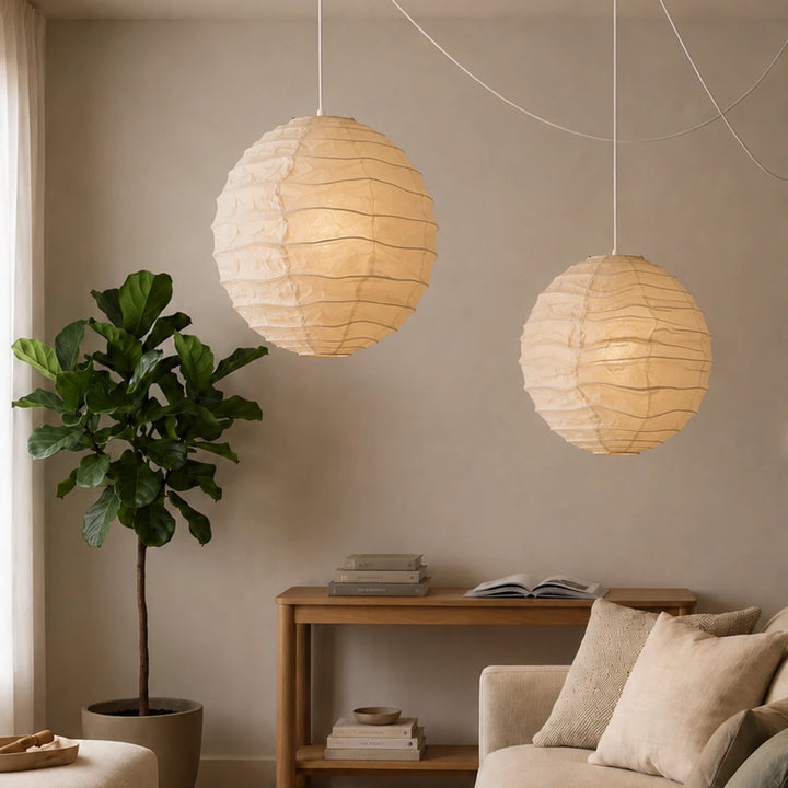 Two paper pendants hanging side by side above an entry console and plant